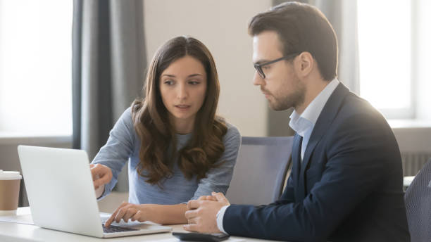 istock Young businesswoman consulting client, coach teaching intern, using laptop 1263022850