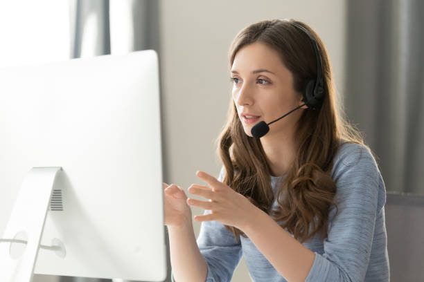 serious female call center operator in headset talking with customer - call center imagens e fotografias de stock