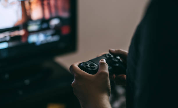 istock A young man holds a game joystick from a console and plays video games. 1263024554