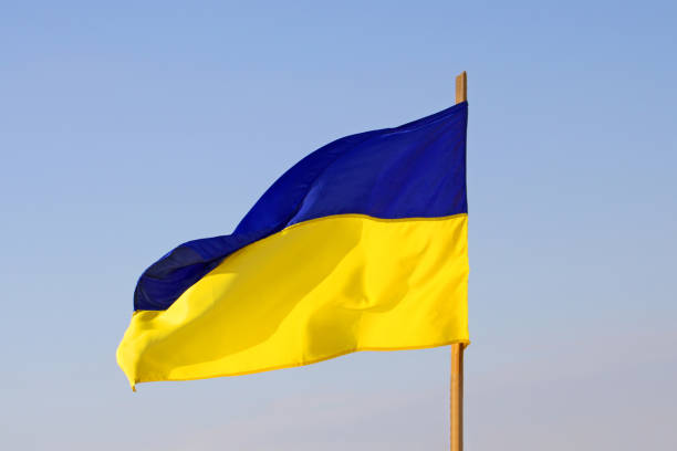 Yellow-blue flag of Ukraine and blue sky as a background. Flag is waving on the wind stock photo
