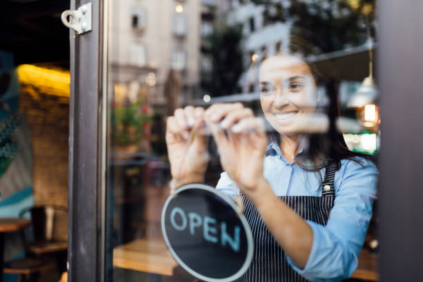 istock Cheerful young waitress opening a cafe 1263027354