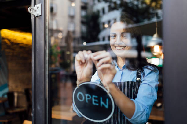 istock Cheerful young waitress opening a cafe 1263027371
