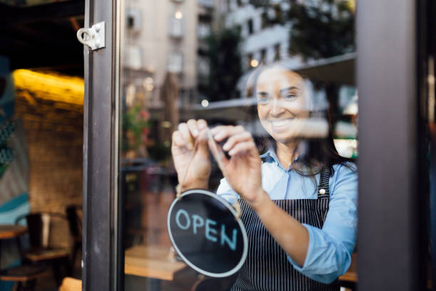 istock Cheerful young waitress opening a cafe 1263027378
