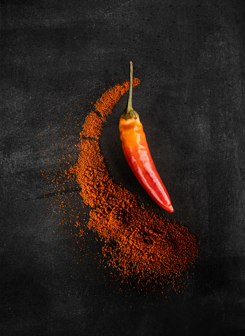 Paprika powder in wooden bowl on white background