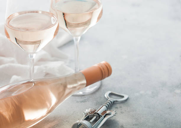 gafas y botella de vino rosado rosa con sacacorchos de acero sobre fondo claro. - cork wine corkscrew old fotografías e imágenes de stock