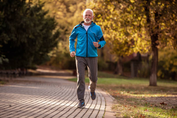 istock Happy senior man jogging in autumn park 1263032945