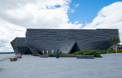 29th July 2020: View along the shore of the River Tay in the city of Dundee in Scotland, looking towards the V&A Dundee modern art gallery. It opened in September 2018 and was designed by Japanese architect Kengo Kuma. The gallery is part of major development and regeneration along the waterfront, in the heart of the city, close to the Tay Bridge. The art gallery is a popular tourist destination with a diverse collection of exhibitions and cultural fashion displays, with the design and boat shaped style of the building now an iconic part of the Dundee skyline.