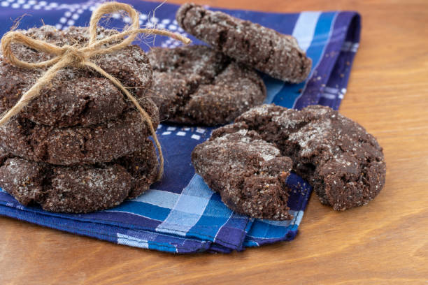 biscotti al cioccolato su tavolo di legno. biscotti zuccherati choco appena sfornato su tovagliolo scuro - biscotti cookie morning temptation foto e immagini stock