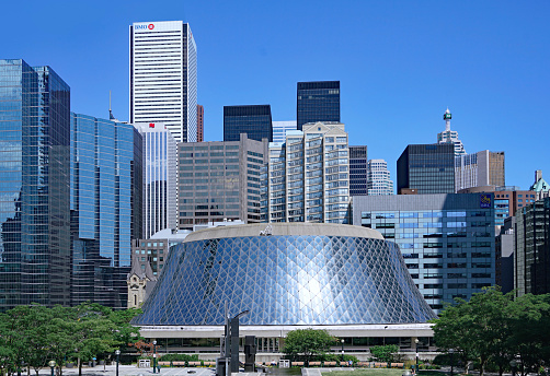 Toronto, Canada - July 31, 2020:  Toronto financial district skyline with Roy Thomson Concert Hall in the foreground.