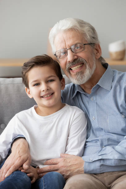 istock Vertical image grey-haired elderly grandfather embraces little grandson 1263052878
