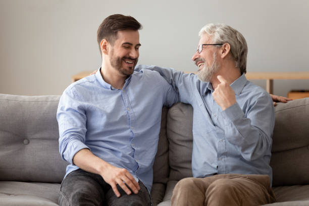 istock Old father grownup son laughing having fun sitting on sofa 1263052938