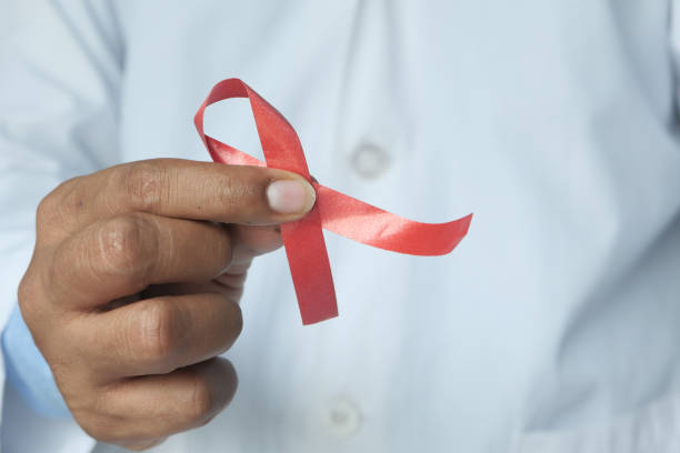 istock hand holding red HIV ribbon with copy space 1263056583