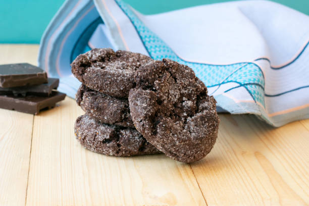 pila di biscotti al cioccolato su tavolo di legno. biscotti zuccherati choco appena fatti in casa su sfondo blu - biscotti cookie morning temptation foto e immagini stock