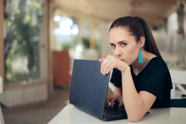 Woman with Laptop Worried About Online Privacy of Personal Data Girl trying to keep her internet data confidential typing password in secret computer hacker spy computer crime laptop stock pictures, royalty-free photos & images