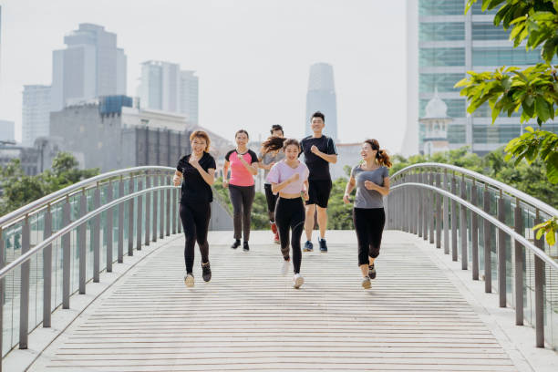 Group of young asian jogging through city park