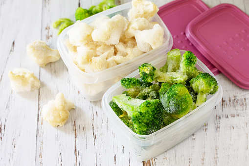 Healthy frozen food for the winter. Containers with frozen cauliflower and broccoli.