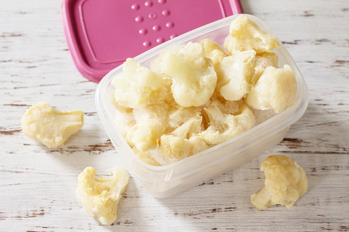 Healthy frozen food for the winter. Containers with frozen cauliflower.