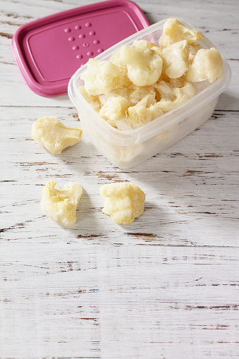 Healthy frozen food for the winter. Containers with frozen cauliflower.