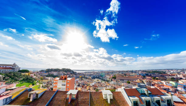 Panoramic view on fast moving clouds in the blue sky over the terracotta rooftops in the centre of Lisbon.