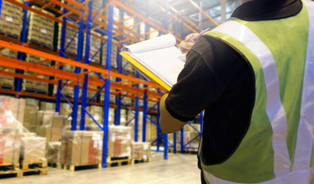 istock Warehouse inventory management, Worker hand holding clipboard his checking details cargo in warehouse storage. 1263075782