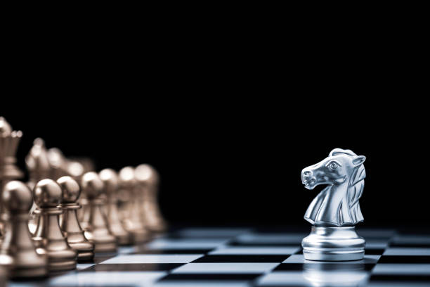 istock Silver horse chess encounters with gold chess enemy on chess board and black background. Market or business competitor concept. 1263080904
