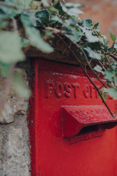 istock Retro red mailbox in Cotswolds, UK, selective focus, framed by an ivy plant. 1263086220