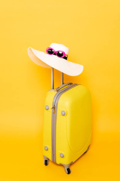 istock sun hat and sunglasses on suitcase handle on yellow background 1263087153