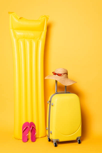 istock travel bag near pool float with beach accessories on yellow background 1263087157