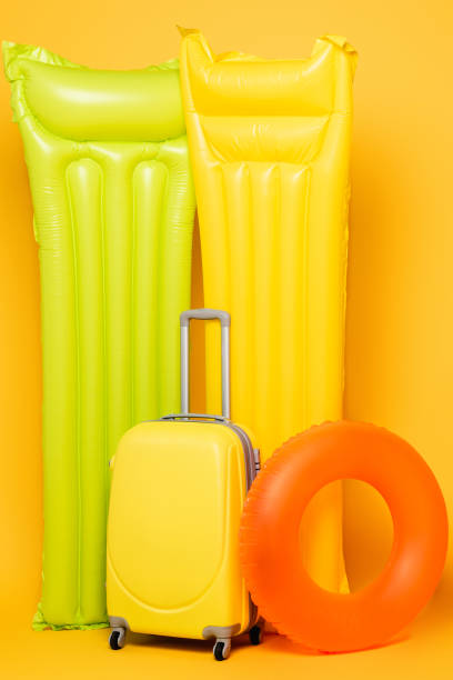 istock travel bag with pool floats on yellow background 1263087159