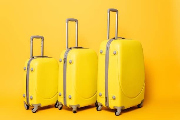 istock stack of travel bags on yellow background 1263087174