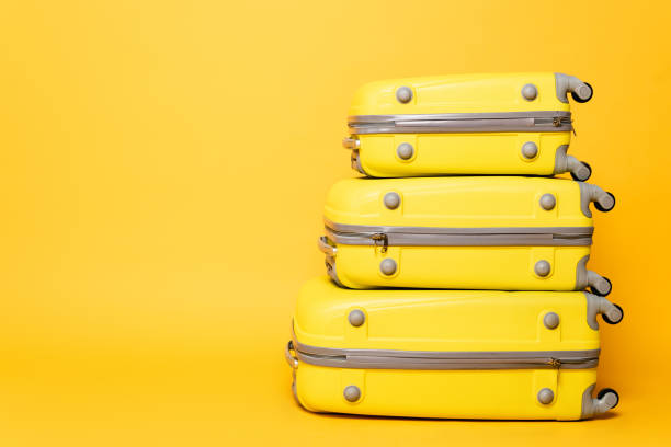 istock stack of travel bags on yellow background 1263087183
