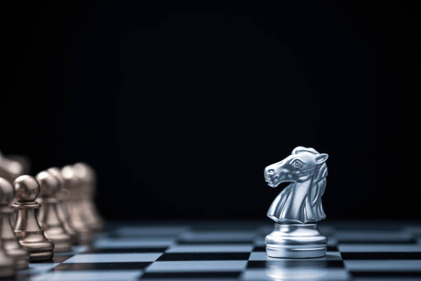istock Silver horse chess encounters with gold chess enemy on chess board and black background. Market or business competitor concept. 1263088835