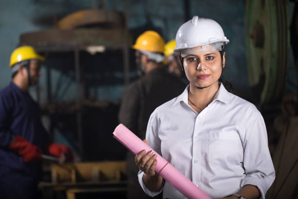 istock Confident female engineer holding blueprint at factory 1263091188