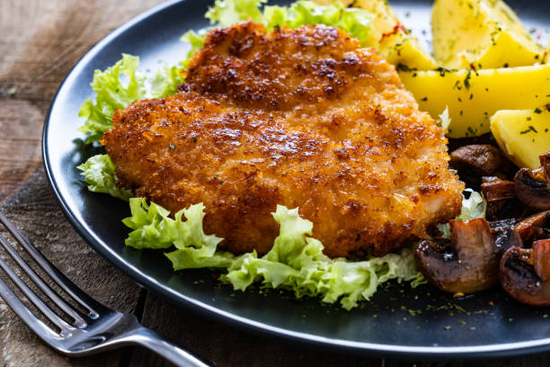 istock Fried pork chop and vegetable salad on wooden table 1263093155