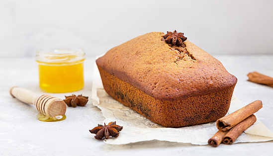 Spicy honey cake with cinnamon and anise star on light grey concrete background. Honey cake for Rosh Hashanah.
