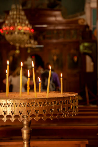 istock Candles placed on a metal try and lit during a religious observance in a church 1263098045