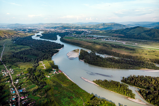 Village in Russia, Altai Mountains, houses and Katun River. Top view of the mountain river in the Altai mountains and the village of Aya. Altai territory.