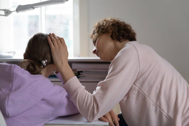 後方ビュー思いやりのある母親は動揺うつ病の10代の娘を慰める - mental health relationship difficulties teenager divorce ストックフォトと画像