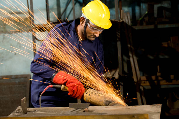 istock Mechanic using circular saw grinder tool with protective workwear at factory 1263102773