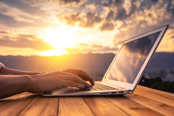 istock Close-up hand typing on laptop with sunlight 1263103220