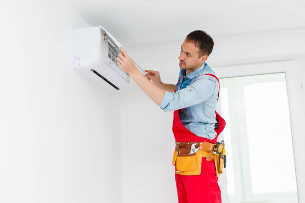 istock Young Man Repairing Air Conditioner Standing On Stepladder 1263103347