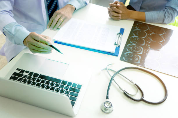 istock Doctor sitting at the table looking at the laptop 1263104518