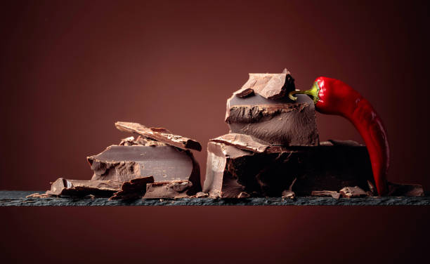 istock Black chocolate with red pepper on a brown background. 1263104724