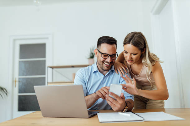 istock Couple at home office, looking at something on smart phone. 1263105016