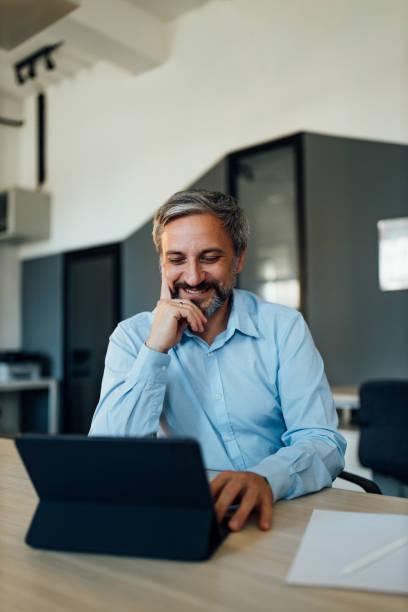 istock Smiling adult men, using digital tablet. 1263105075
