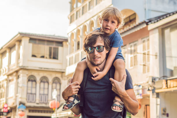 Dad and son are tourists on the Street in Phuket Dad and son are tourists on the Street in Phuket driveway colonial style house residential structure stock pictures, royalty-free photos & images