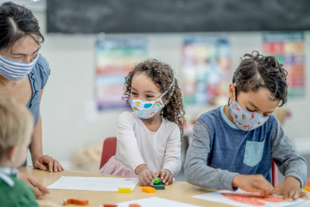 istock Group of children colouring while wearing masks 1263108043