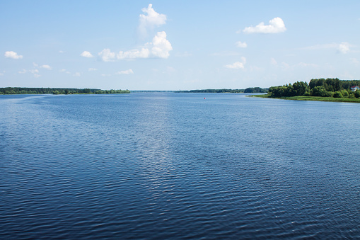 The wide riverbed of the Volga river and the blue cloudy sky on a clear summer day and space for copying