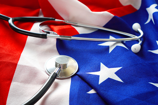 Disease Control in America concept with the medical stethoscope lying on the USA Flag.