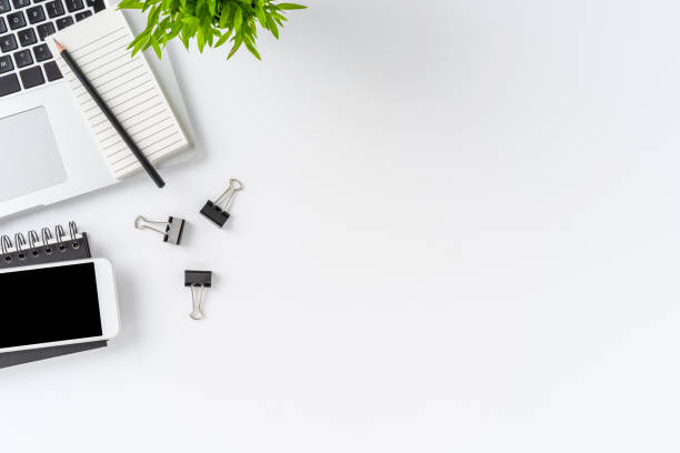 istock Overhead shot of modern workplace with laptop and accessories on white table with copyspace. Office desktop. Flat lay 1263109539